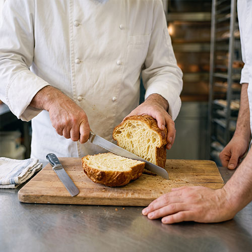 Pâte à brioche élastique montrant un beau réseau glutineux dans la cuve d'un batteur professionnel.